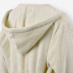 Close-up of the back of a cream terry cotton bathrobe showing the hood detail.
