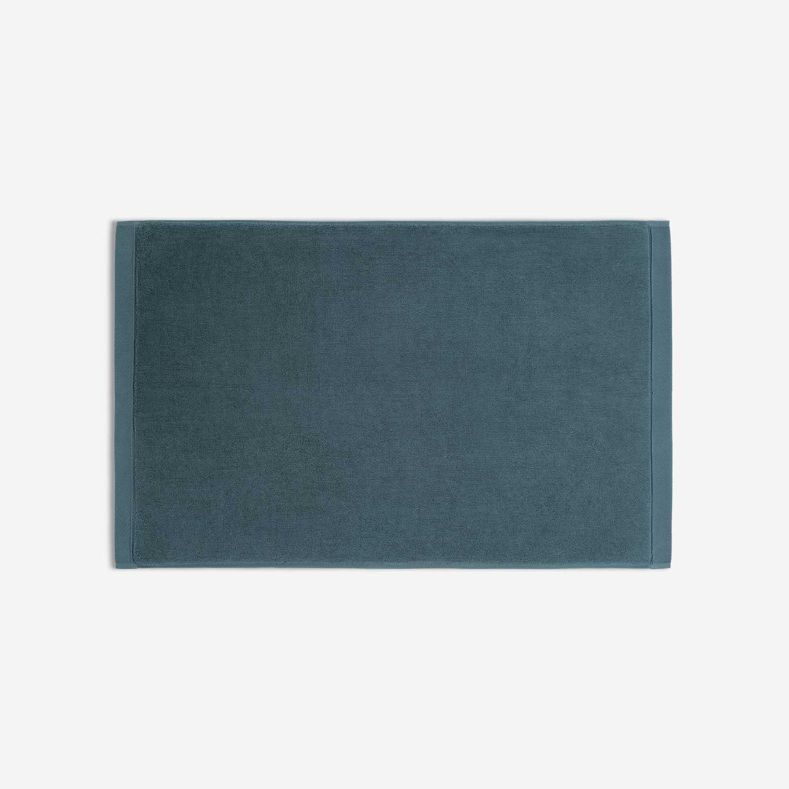 Teal cotton bath sheet in horizontal orientation with woven border bands, shown against a white background.