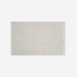 Light beige cotton bath sheet in horizontal orientation with woven border bands, shown against a white background.