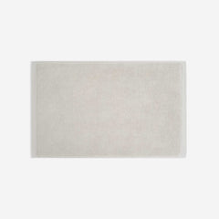 Light beige cotton bath sheet in horizontal orientation with woven border bands, shown against a white background.