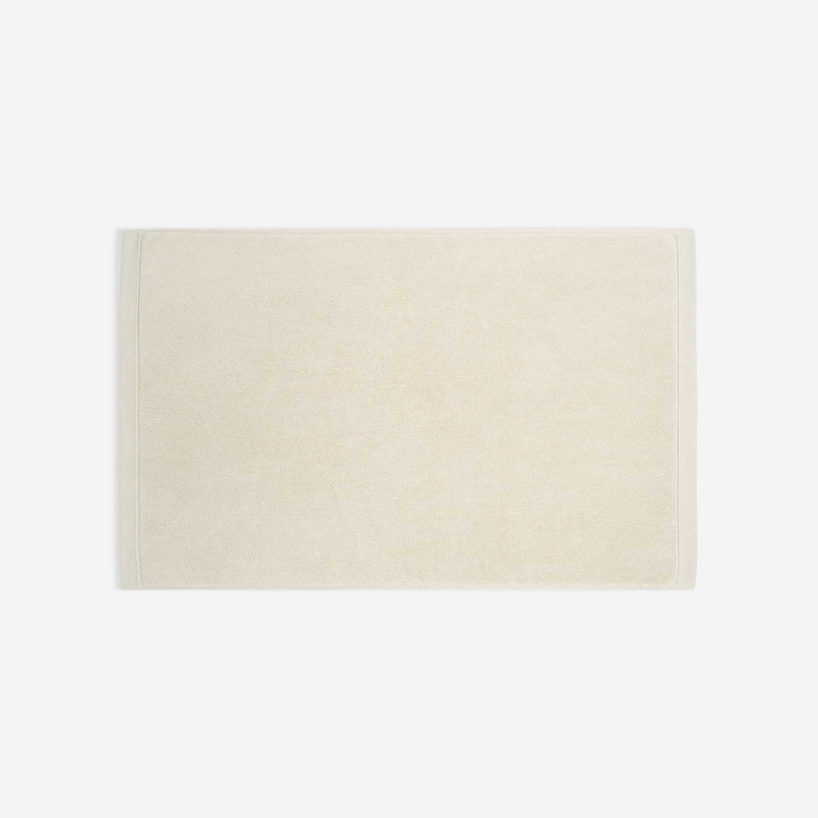 Cream cotton bath sheet in horizontal orientation with woven border bands, shown against a white background.