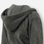 Close-up of a dark grey terry cotton bathrobe showing the hood detail and plush texture.