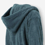 Close-up of a teal terry cotton bathrobe showing the hood detail and plush texture.
