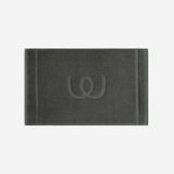 Charcoal gray bath mat with a tonal embroidered logo, shown in horizontal orientation against a white background.