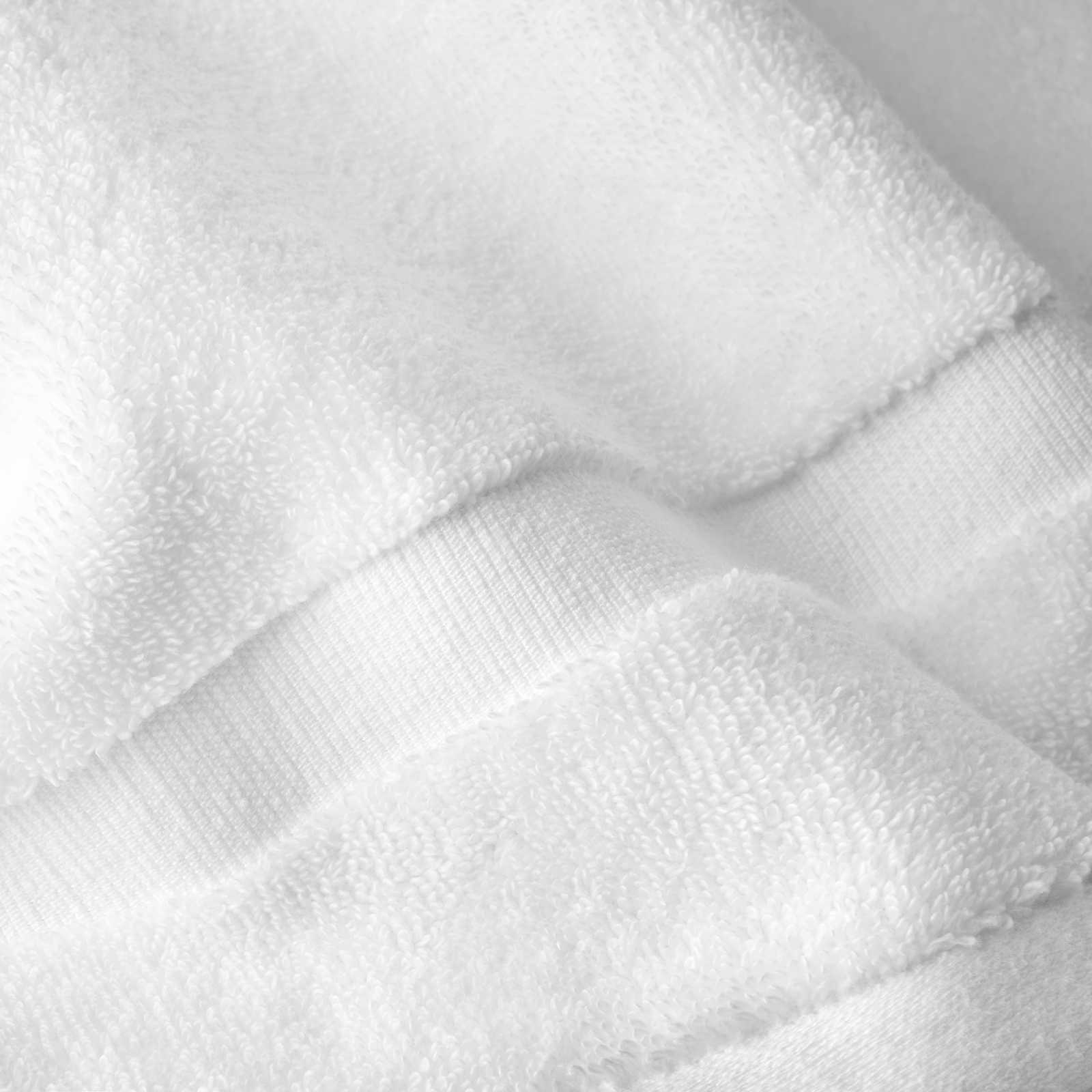 Close-up of a white cotton bath sheet highlighting the dense terry texture and woven border detail.