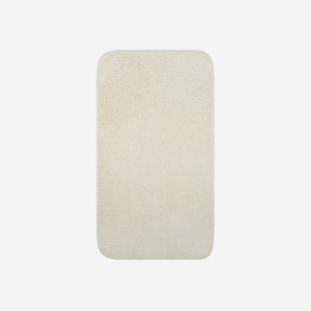 Top view of a light cream cotton bath towel with rounded corners, displayed flat on a white background.