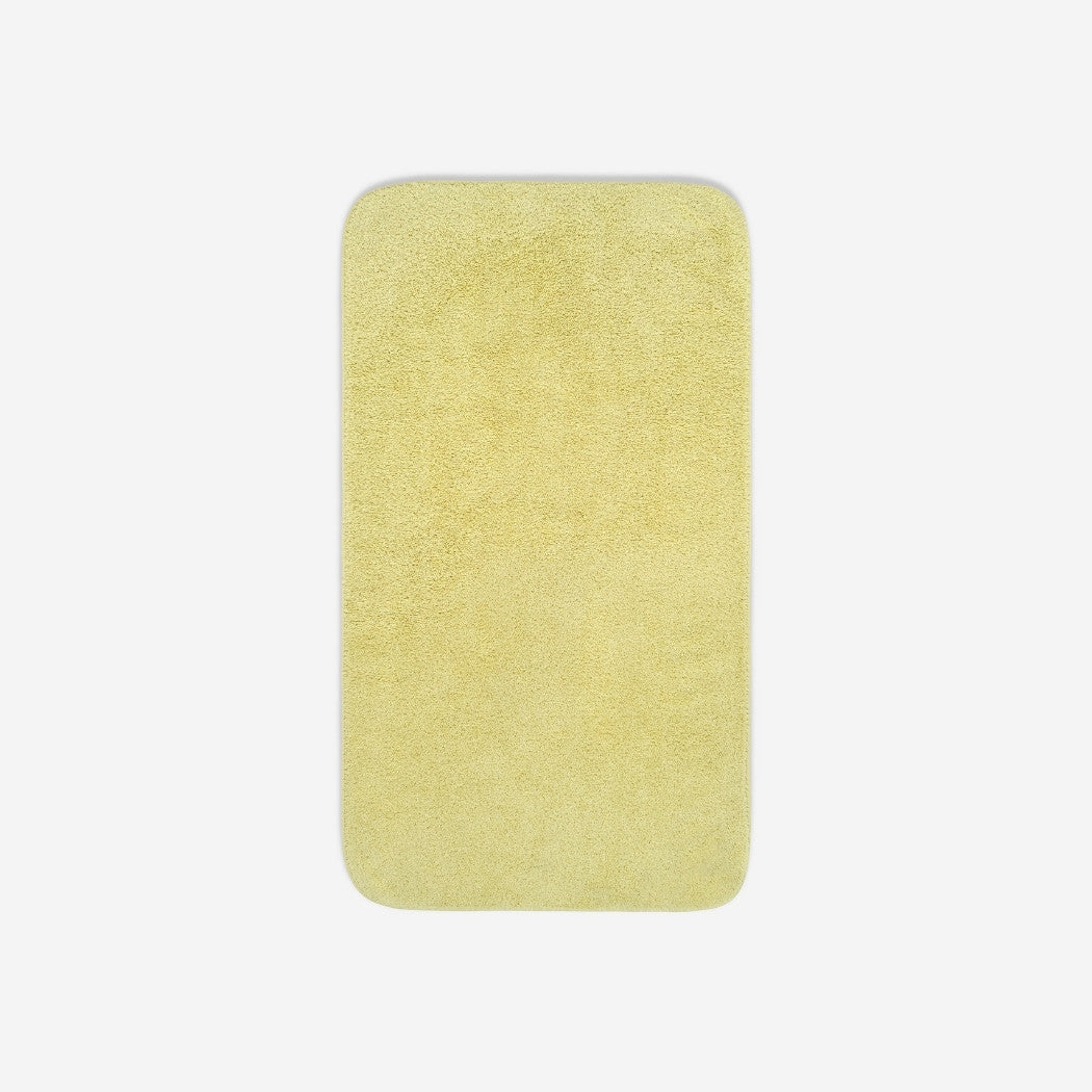Top view of a yellow organic cotton towel laid flat with rounded corners, shown on a white background.