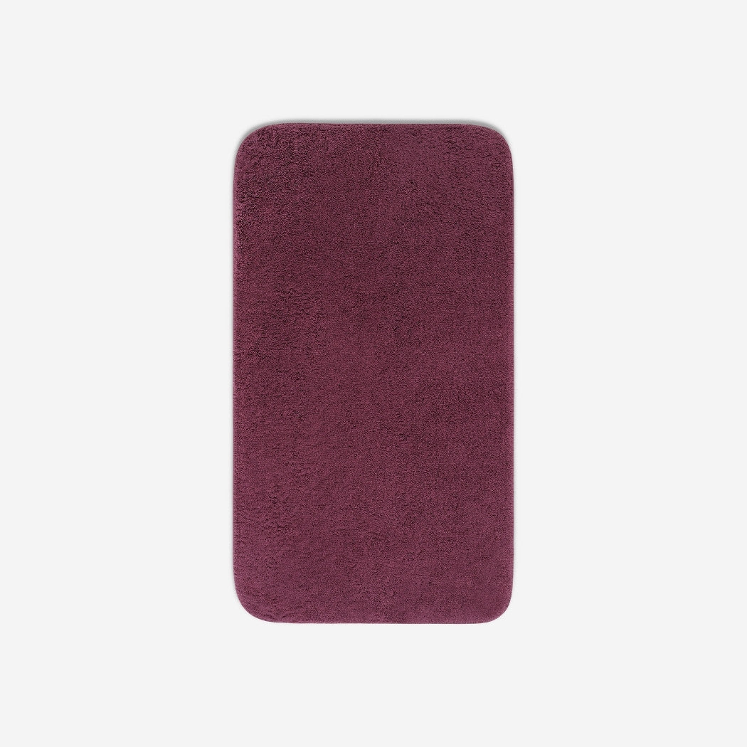 Top view of a purple cotton bath towel with rounded corners, displayed flat on a white background.