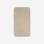 Top view of a beige cotton bath towel with rounded corners, displayed flat on a white background.