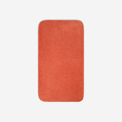 Top view of an orange organic cotton bath towel with rounded corners, displayed flat on a white background.