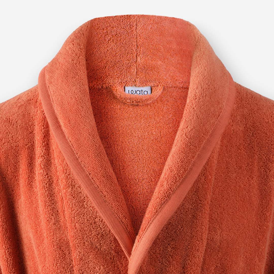 Shawl collar detail of WATA VIVO organic cotton bathrobe in terracotta.