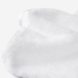 Close-up of a white cotton towel highlighting the soft terry texture and integrated white hanging loop detail.