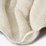 Close-up of a light cream cotton towel highlighting the soft terry texture and integrated matching hanging loop detail.