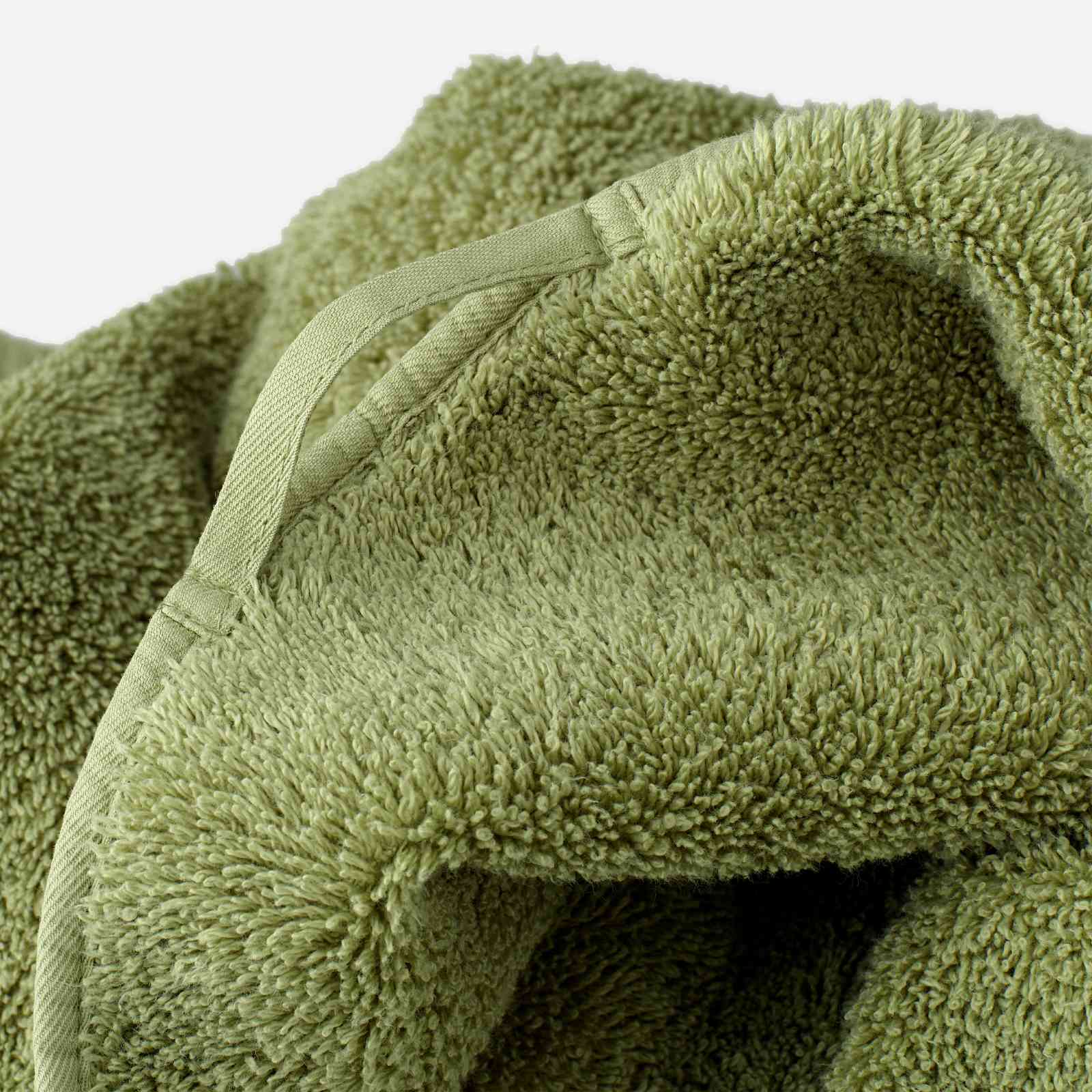 Close-up of an olive green towel showing the terry texture and a fabric hanging loop stitched into the edge seam.