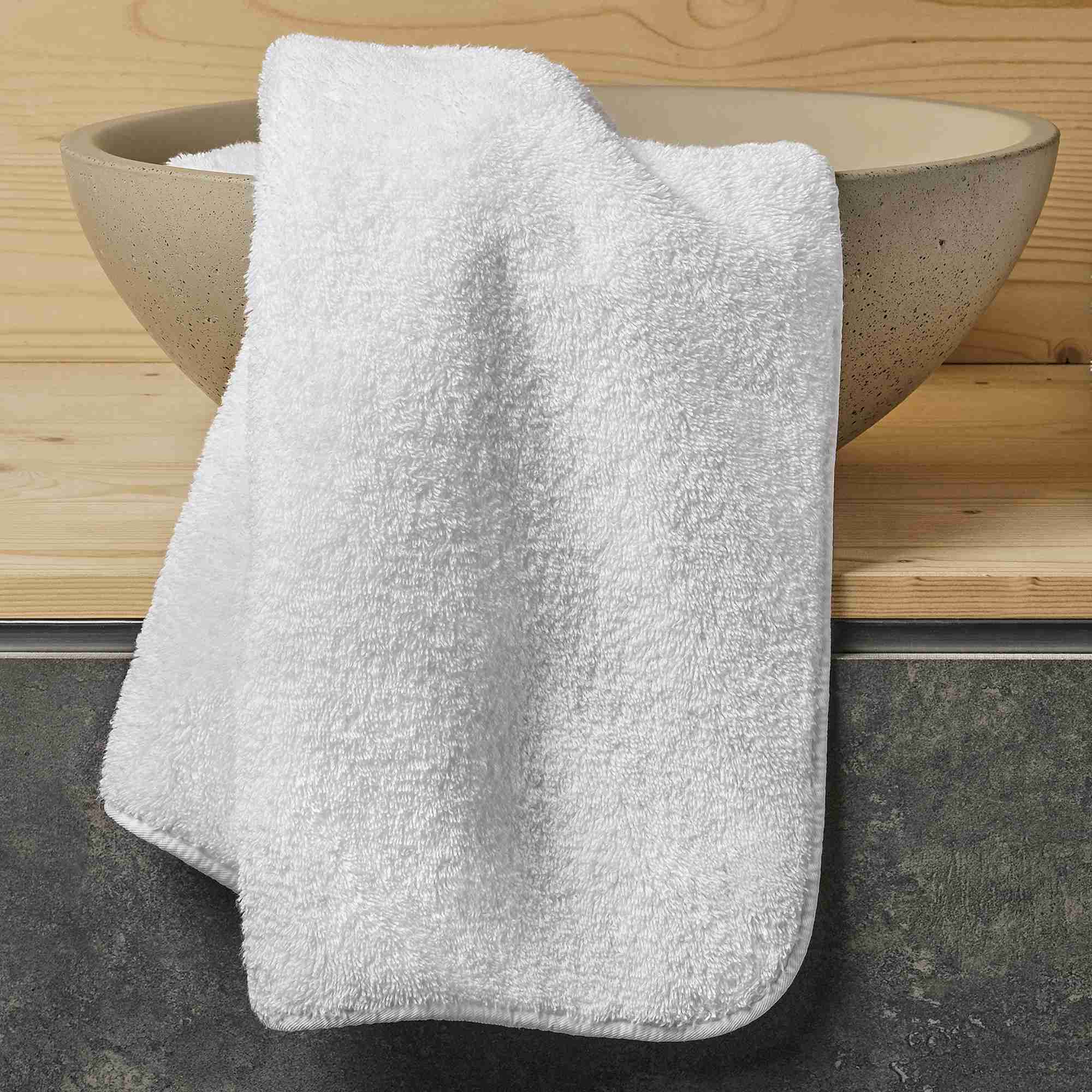 White towel draped over a stone bowl on a wooden surface