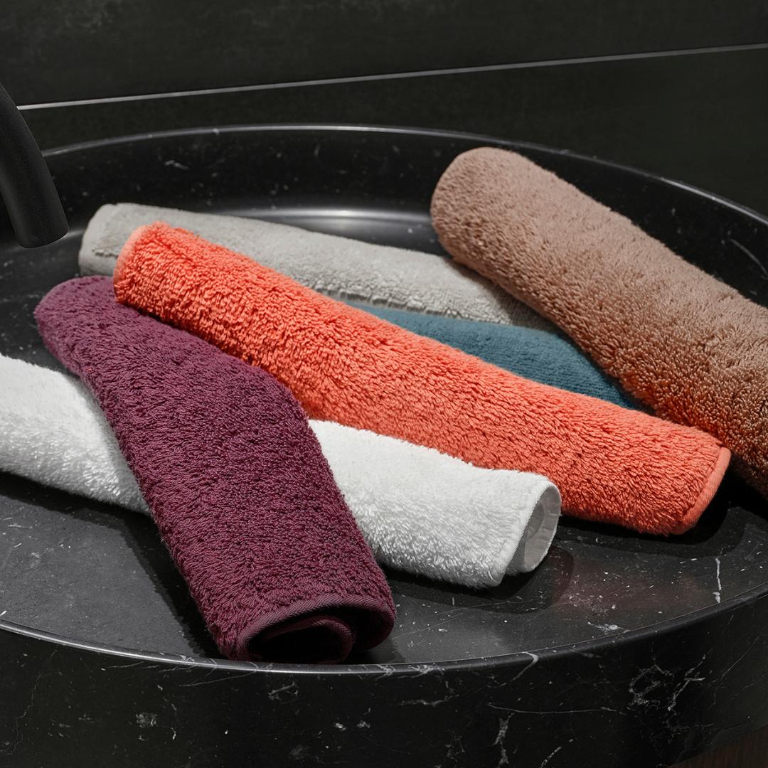 Set of colorful washcloths on a black marble surface.