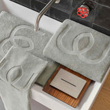 Gray bath mats with textured design on a bathtub