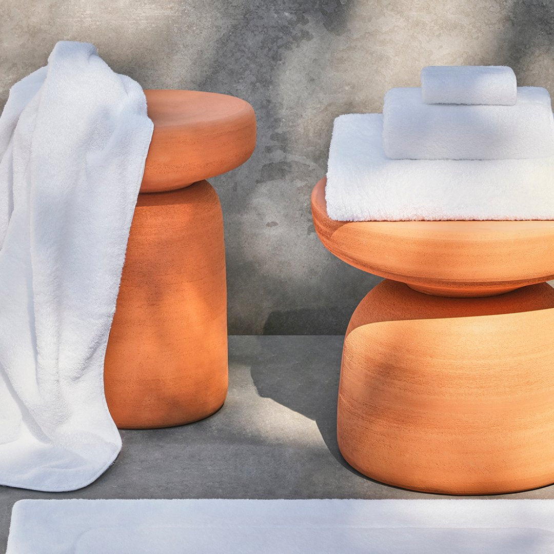 White bath towels displayed on terracotta stools