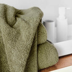 Green towel on a wooden surface with a blurred background.
