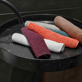 A stack of colorful face towels on a black marble surface.